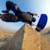 Skydiver with black and blue canopy flying around the Egyptian pyramids