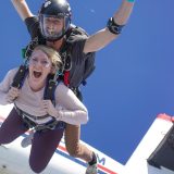 Female tandem skydiving student screaming in freefall