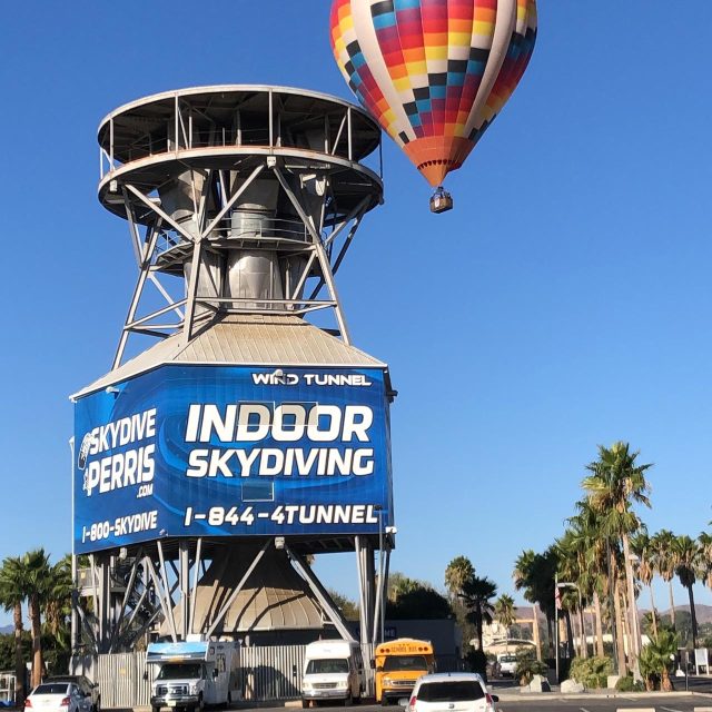 Hot air balloon beside an exterior view of the wind tunnel at Skydive Perris