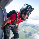 Experienced skydiver standing in the door of an airplane preparing to jump