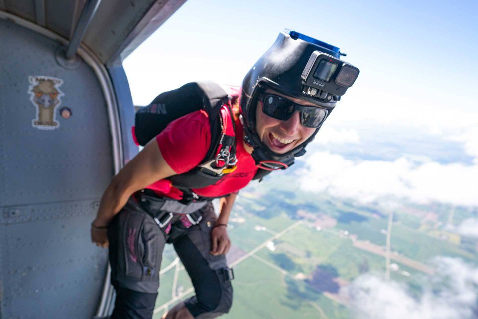 Experienced skydiver standing in the door of an airplane preparing to jump