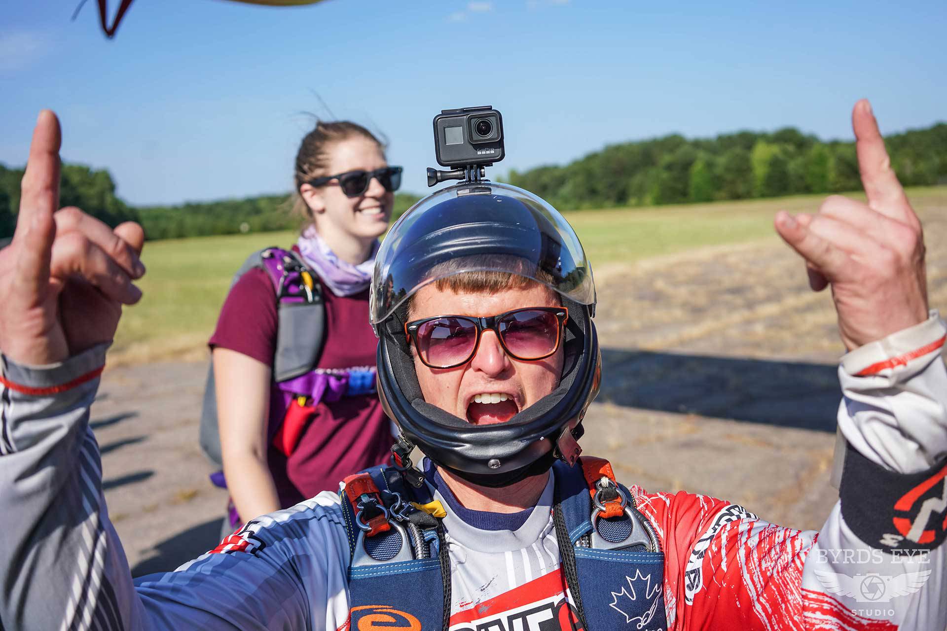 Licensed skydiver preparing to board aircraft giving rock on sign with his hands